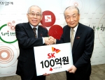 조정남(오른쪽) SK텔레콤 부회장이 사회복지공동모금회 이세중 회장에게 100억원을 전달하고 있는 사진