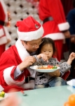 송화종 삼천리 이사가 산타클로스가 되어 경동원 아이들에게 음식을 먹여주고 있다.