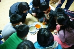청소년 건강학교 참가자들이 청량음료에 금붕어를 담가 실험하고 있다.
