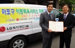 오종희 LG복지재단부사장(사진오른쪽)이 신영섭 마포구청장에게 이동목욕차량 기증서를 전달하고 있다.