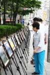 에스넷 사옥 야외에 마련된 사진동호회 작품전시회를 감상하고 있는 에스넷 직원 및 지역 주민들.
