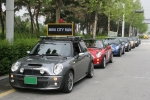 루프위에‘MINI CITY RUN’ 보드를 얹은 에스코트 MINI 차량을 선두로 다양한 색상의 MINI 쿠퍼가 줄지어 신호를 대기하고 있다. 