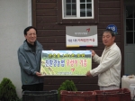 강주안 아시아나항공 사장(좌측)이 변해동 외삼포2리 이장(우측)에게 우렁이 900kg에 대한 기증서를 전달하고 있다. 
