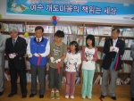 삼성SDS가 여수 개도마을에 어린이 도서관을 만들고 책을 기증한 후 개관식 테이프 커팅을 아이들과 하고 있다