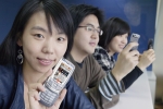KTF 도우미가 휴대폰으로 새롭게 개편된 멀티미디어 서비스 ‘쇼 비디오’를 보고 있다