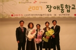 SK, 보건복지부, 한국지역자활센터협회에서 공동으로 주최한 [2007 장애통합교육 수기 공모전]에서 으뜸상을 수상한 장애통합교육보조원들과 SK텔레콤 사회공헌 팀 김도영팀장(왼쪽),