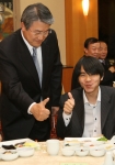 이세돌 9단이 박승호 포항시장으로부터 과메기 먹는 법 설명을 듣고 과메기를 먹은 뒤 엄지 손가락을 내밀고 있다
