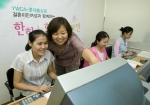 롯데홈쇼핑-YWCA ‘한하늘한땅’ 정보화교실에서 강사의 도움을 받아 컴퓨터 실습 중인 결혼이민여성