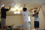 봉사단들이 천정 도배 작업을 하고 있다.
