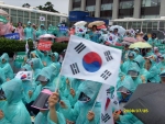 7월 25일 보건복지부 앞마당에서 시민들이 폭우 속에서 황우석 박사의 국내연구 승인을 보건복지부에 촉구하고 있다. 