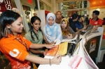 말레이시아 고객이 U모바일 대리점에서 휴대폰 가입설명과 서비스에 대해 설명을 받고 있다.