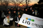 1일 새벽, 광교산 형제봉에 오른 LIG손해보험 김우진 사장(3열 좌측 4번째)과 임직원들이 해돋이를 배경으로 2009년 새해 결의를 다지고 있다.