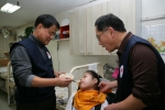 한전 김쌍수 사장이(왼쪽) 장애아동(가운데)에게 밥을 먹여주는 모습(홀트일산복지타운)