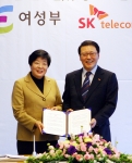 변도윤 여성부 장관(左)과 정만원 SK텔레콤 사장이 협약서를 들고 포즈를 취하고 있다.