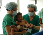 의료 NGO 글로벌케어 언청이 및 안면기형 어린이 수술팀이 수술이 무서워서 우는 언청이어린이를 달래는 장면