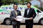 남상건 LG복지재단 부사장(왼쪽)이 조윤길 옹진군수에게 이동목욕차량 자동차 키 모형을 전달하고 있는 모습.