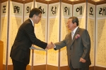 구자경 LG 명예회장(오른쪽)이 해외연구교수로 선발된 고정상 부산대학교 기계공학부 교수에게 해외연구 지원증서를 수여하고 악수를 나누는 모습