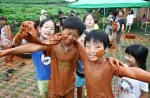 풀무원의 '굿바이 아토피!' 캠프에 참가한 어린이들이 황토 염색 체험을 하며 즐거워하고 있다.