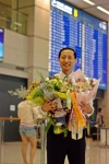 박길영 수석사무장이 3만시간 비행기록 돌파를 기념하는 꽃다발을 들고 포즈를 취하고 있다.