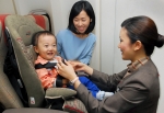 아시아나항공 승무원이 기내 유아용 안전의자(Baby Seat)의 벨트를 고정시키고 있다. 아시아나는 업계최초로 10월 1일부터 기내에서 미국 연방항공국(FAA)의 승인을 받은 유아