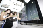 삼성전자에서 이번 한국전자전에 출품한 3D TV를 삼성전자 홍보 도우미들이 고객과 함께 시연하고 있다.