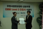 서광현 우정사업정보센터장(왼쪽)이 19일 장택상 CMMI공인인증 한국대표심사위원으로부터 인증서를 수여받고 있다. <사진제공 : 우정사업본부>