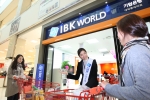 기업은행 직원이 롯데마트 대덕점에서 쇼핑 중인 고객에게 이날 오픈한 IBK월드를 안내하고 있다.