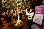 LG CNS 승진자 가족초청 축하행사에서 가족들이 축하의 메세지를 담은 사랑의 열매를 '사랑의 응원 나무'에 매달며 흐뭇한 웃음을 짓고 있다.  