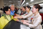 김포공항 아시아나 국내선 카운터에서 시니어 승객들이 아시아나 '카네이션 존(zone)' 서비스에 대한 설명을 들으며 즐겁게 수속하고 있다.