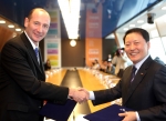 SK텔레콤 정만원 CEO와 월트디즈니 앤디 버드(Andy Bird) 회장이 계약서에 서명한 후 악수하는 모습