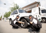 한국타이어 점검 요원이 한국타이어 무상 안전점검 서비스 행사장에서 고객의 타이어를 점검하고 있다.
