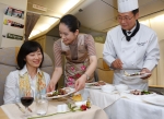 조리사 복장을 입은 아시아나 셰프 승무원(우측)이 승객에게 요리를 서비스 하고 있다.