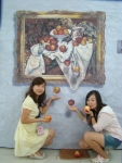 일본에서 유학온 학생들이 세잔의'사과와 오렌지'패러디앞에서 떨어지는 서과를 받으려는 포즈를하고 있다