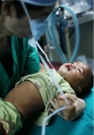 안면기형수술을 받기 위해 라오스 어린이를 수술실로 옮기고 있다(2010).