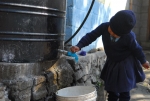 글로벌케어 해외아동지원사업을 통해 후원하는 아동이 물탱크에서 깨끗한 물을 받고 있다.