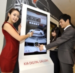 디지털 사이니지가 적용된 기아차 지점에서 고객들이 인터랙티브 터치 스크린 ‘기아 디지털 갤러리(Kia Digital Gallery)’를 작동해 차량 정보를 보는 모습.