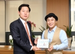 우정사업본부 김기덕 경영기획실장(왼쪽)이 1일 우정사업본부에서 우체국 국제특송 EMS 홍보대사로 위촉된 개그맨 김병만 씨에게 달인 캐릭터로 제작한 나만의 우표를 전달하고 있다.