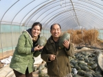 한국 농가를 찾은 외국인 우퍼가 한국인 농부와 함께 추수한 호박을 들어보이며 웃고 있다.