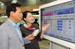 김포공항 국내선 아시아나 카운터 앞에서 대기 승객이 대기손님 안내 모니터 및 아시아나항공 직원을 통해 대기인원 및 순번을 확인하고 있다.