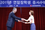 강유식 (주)LG 부회장(왼쪽)이 대표장학생 이화여자대학교 심리학과 석사과정 심기선양에게 장학증서를 전달하고 있다.