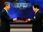 이현동 국세청장(왼쪽)이 2011년 10월 19일(수) SBS 등촌동 공개홀에서 열린「제15회 민원봉사대상 시상식」에서 대상 수상자인 부산진세무서 조봉현 조사관에게 특별승진 심사예