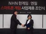 23일, NHN 분당 사옥서 한게임 스마트폰게임사업그룹 채유라 그룹장(오른쪽)과 엔필 이승훈 대표이사(왼쪽)가 스마트폰 게임 사업제휴 조인식을 체결하고 악수를 나누는 모습