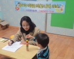 (사)희망지원센터의 관계자가 아동과 1 대 1로 아동발달상황 검사를 진행하고 있다.