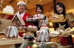 산타복장의 제과장과 프랑스, 독일 전통 의상을 입은 모델들이 유럽의 전통 케이크와 빵을 소개하는 모습