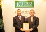 김용복 명예회장(왼쪽)이 장학기금을 전달한 후 김진규 총장(오른쪽)으로부터 감사패를 받고 있다.