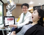 SK텔레콤의 태블릿 PC기반 치과전용 의료 솔루션인 ‘스마트 덴탈’을 도입한 한 치과 병원에서 담당의사가 환자에게 태블릿 PC를 이용해 치료과정을 설명하고 있다.