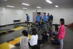 사회복무요원과 지역아동센터 아이들의 휠체어 체험 준비 장면