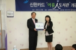 신한카드 이재우 사장(왼쪽)이 5월 3일 오후 경남 남해군 설천리 남해로뎀지역아동센터에서 열린 아름人도서관 개관식에서 고지현 센터장에게 아름인도서관 현판을 전달하고 있다.
