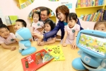 KT 박혜정 홈마케팅본부장(오른쪽)과 한국 삐아제 박종관 회장이 스마트 러닝 교육기관 1호점으로 지정된 ‘이데아 키즈’(서울시 강남구)에서 어린이들과 함께 키봇2로 구연동화를 시청