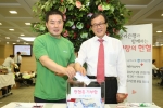 이순우 은행장(오른쪽)과 임혁 노조위원장이 헌혈행사 후 헌혈증을 기부하고 있다.